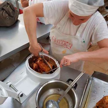 Asador De Pollos Lomarin persona alitando un pollo